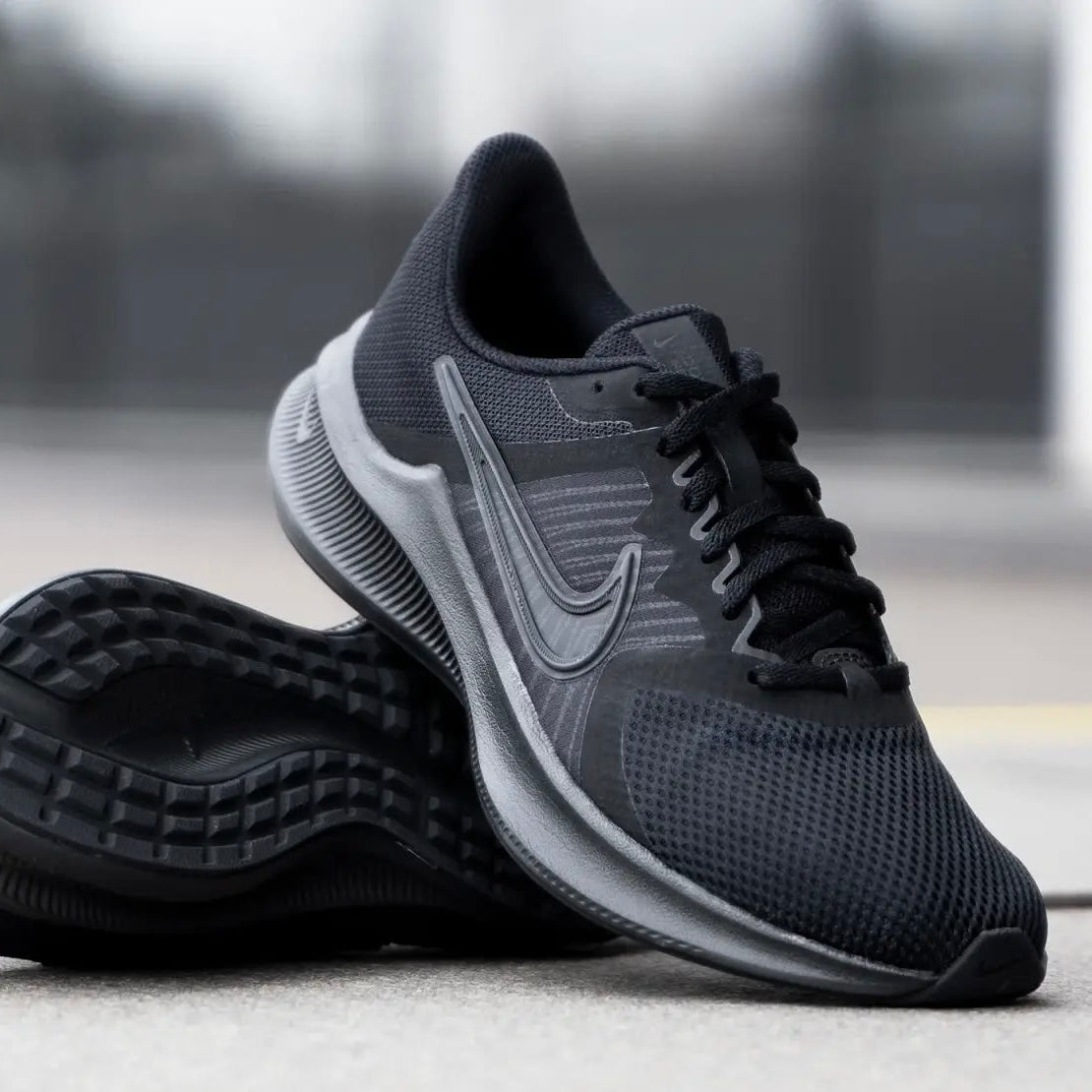 Black running shoe with a visible brand logo on a blurred background